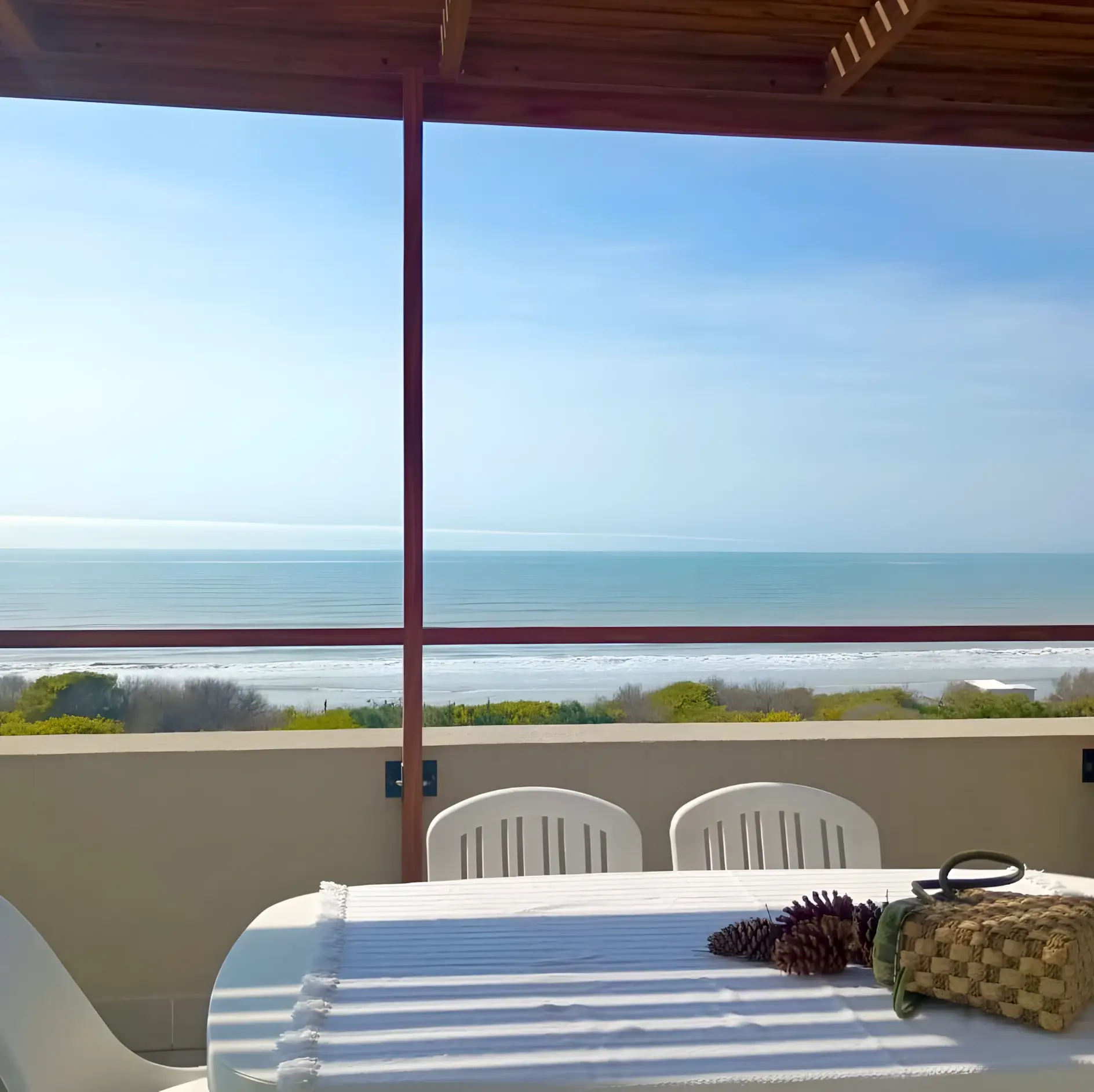 Balcón con mesa, sillas y vista abierta al mar