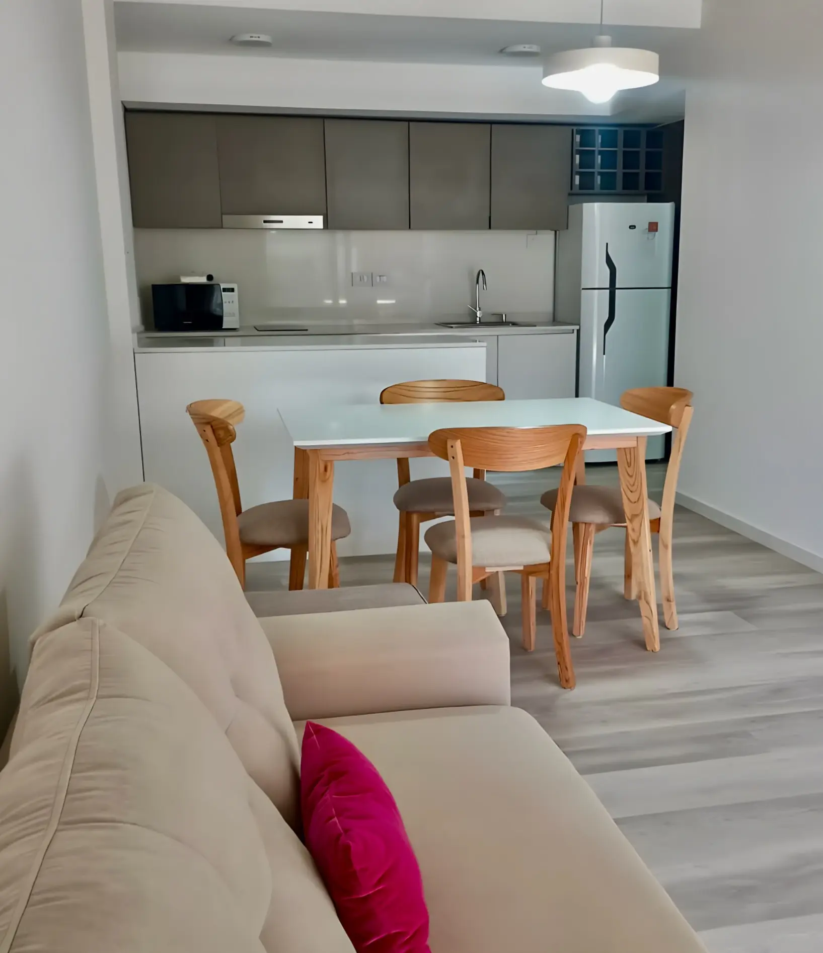 Living comedor integrado con la cocina, sofá y mesa para cuatro