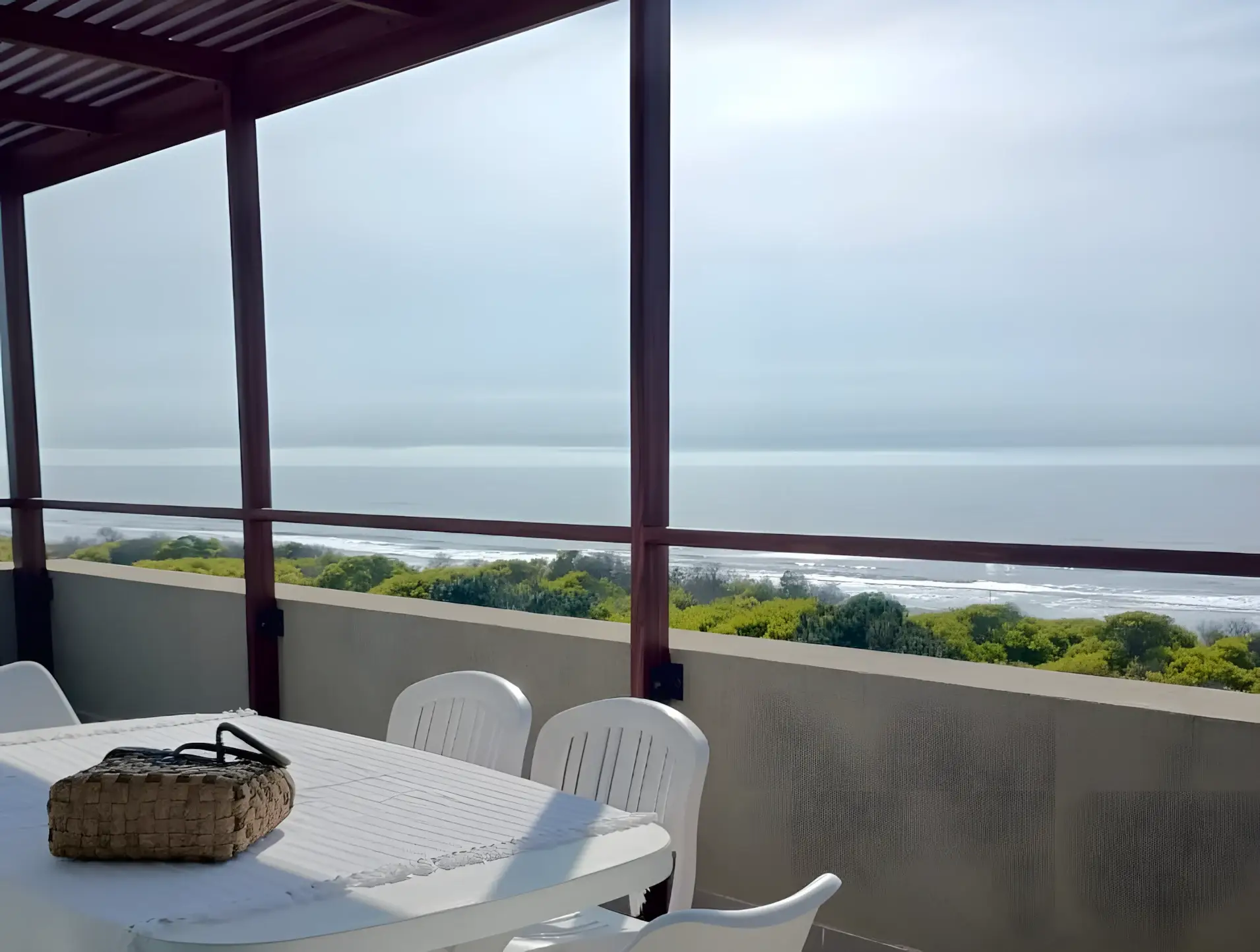 Mesa del balcón con la costa y el pinar al fondo