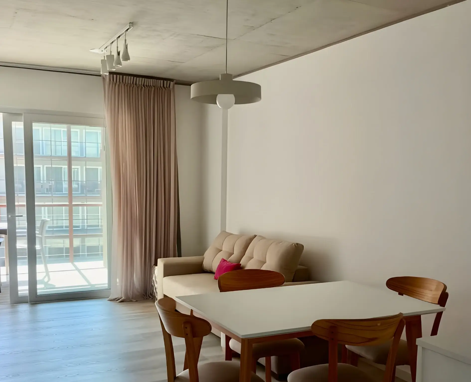 Comedor y sofá junto al ventanal que da al balcón