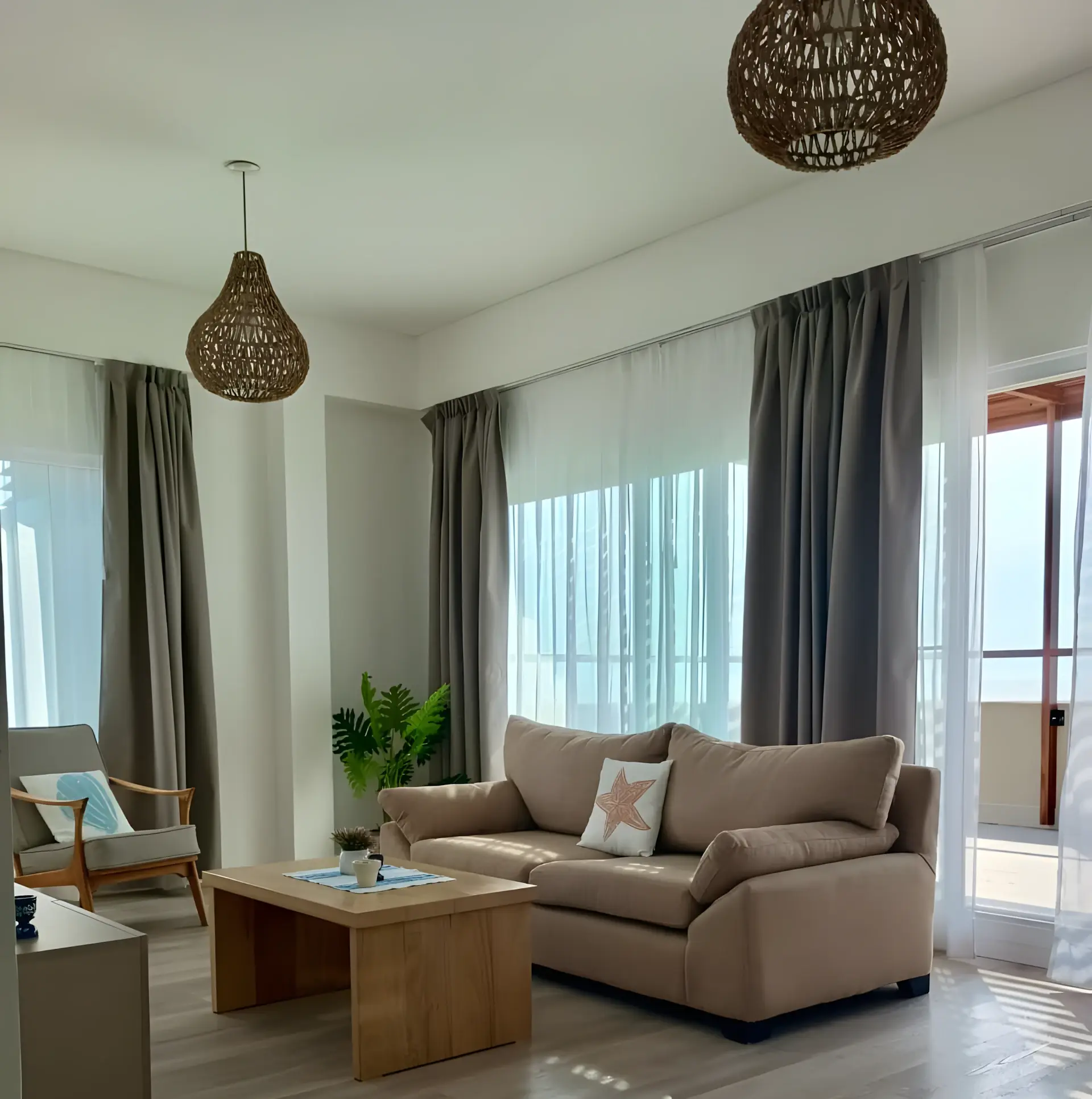 Living con sofás, mesa ratona y ventanal al balcón