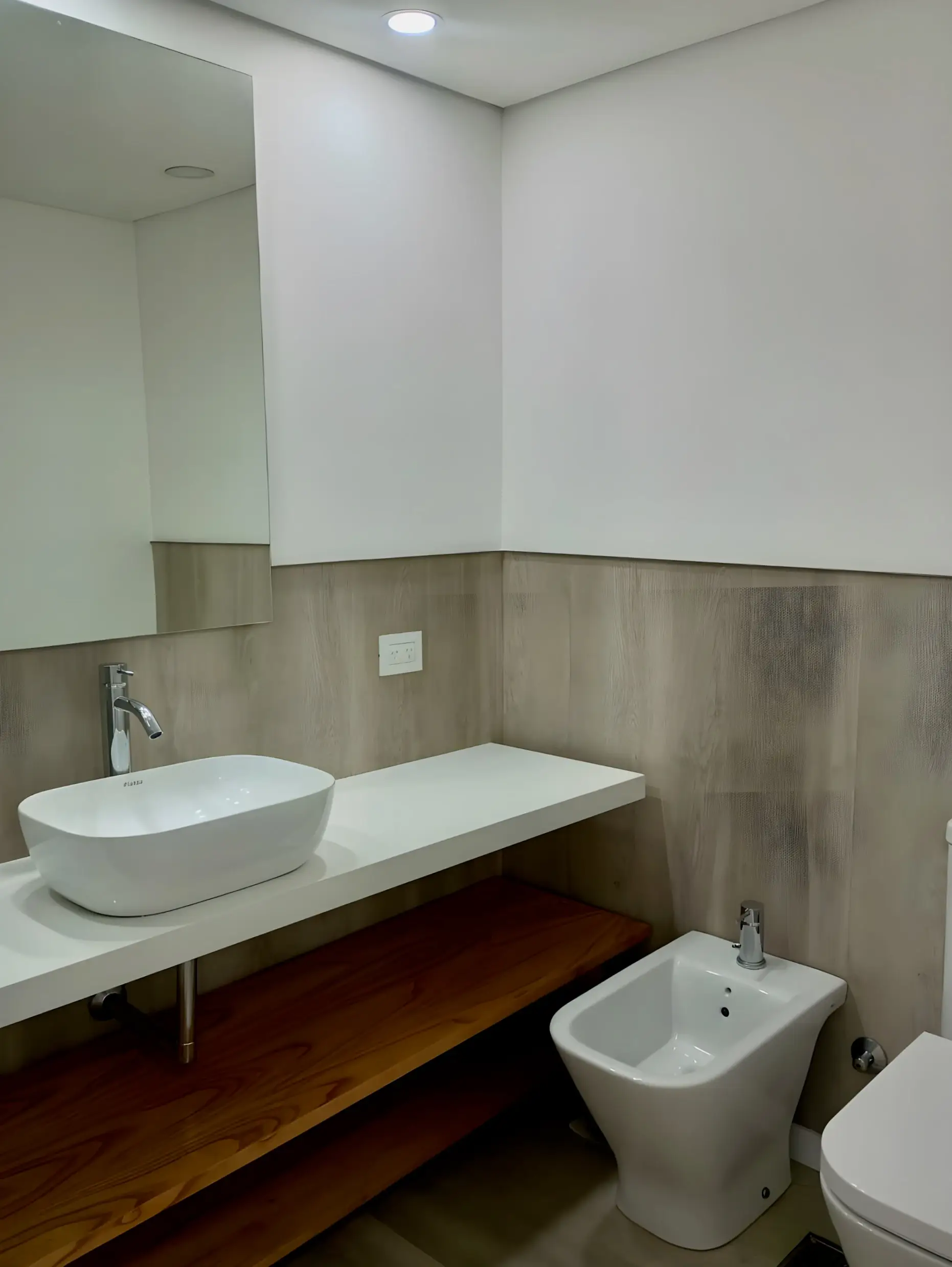 Toilette con bidet, inodoro y bacha sobre mesada de madera