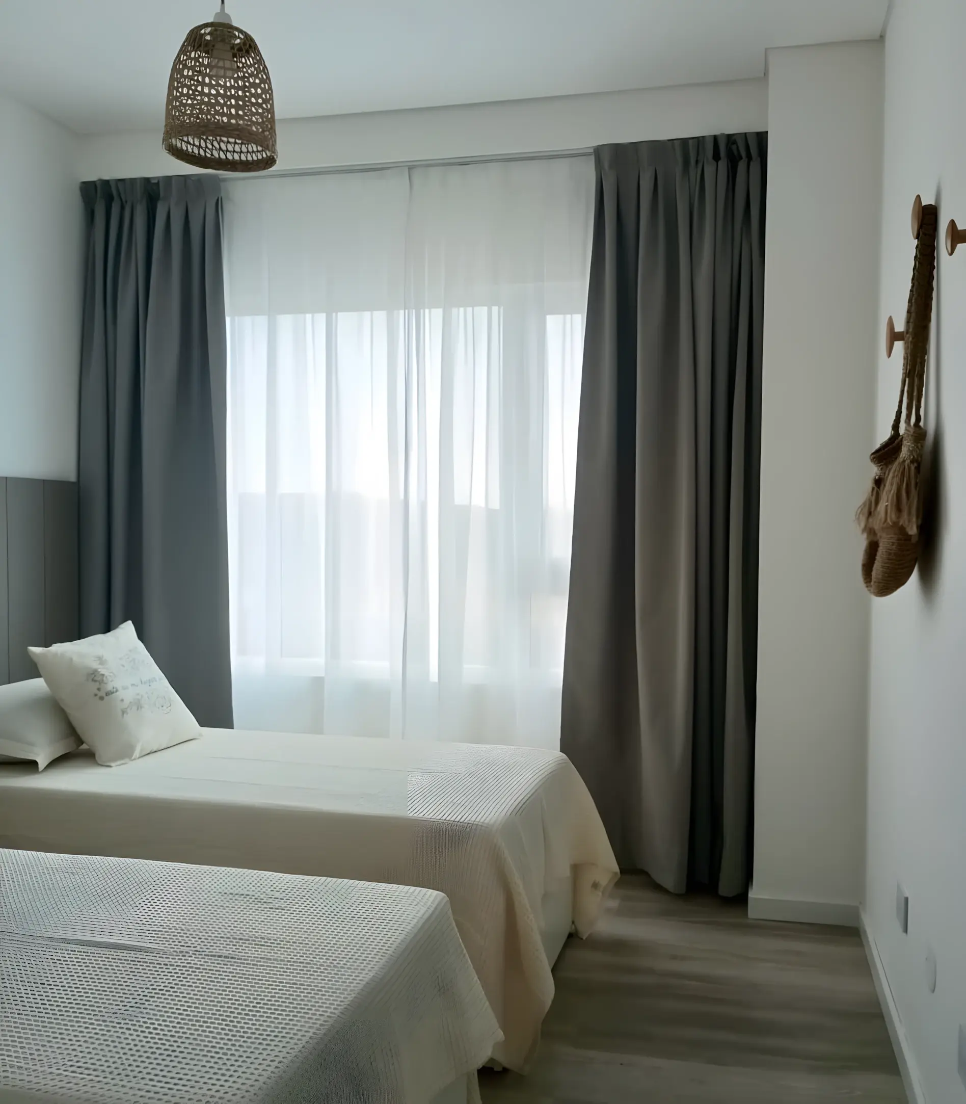 Dormitorio con cortinas y perchero de pared